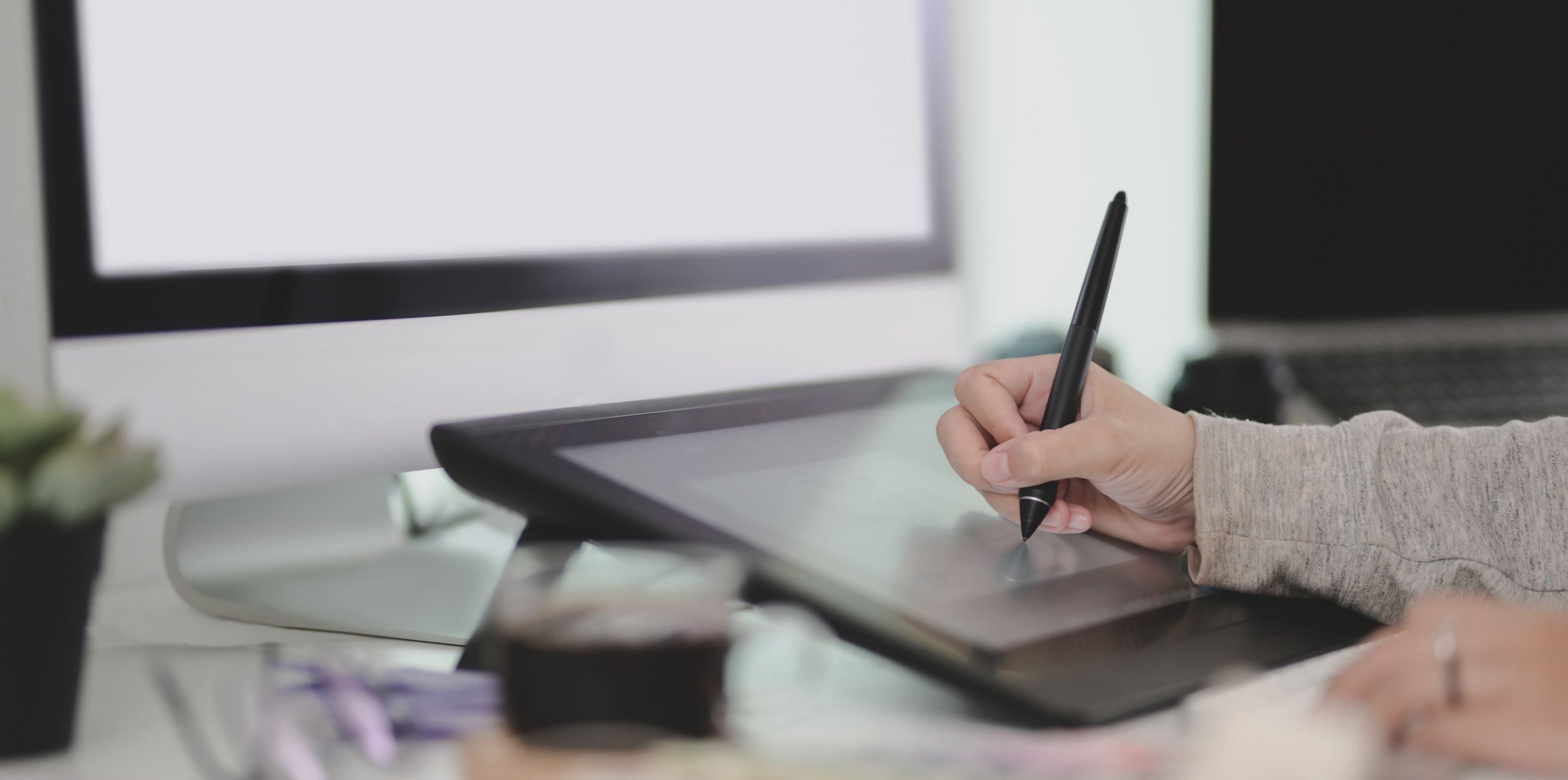 Unrecognizable graphic designer using tablet in office